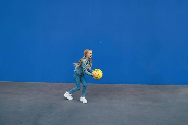 Menina brincando com a bola amarela — Fotografia de Stock