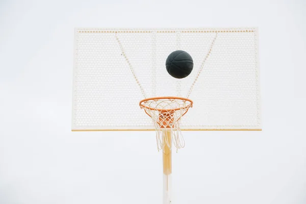 Palla nel cestino in campo da basket all'aperto e palla nera — Foto Stock
