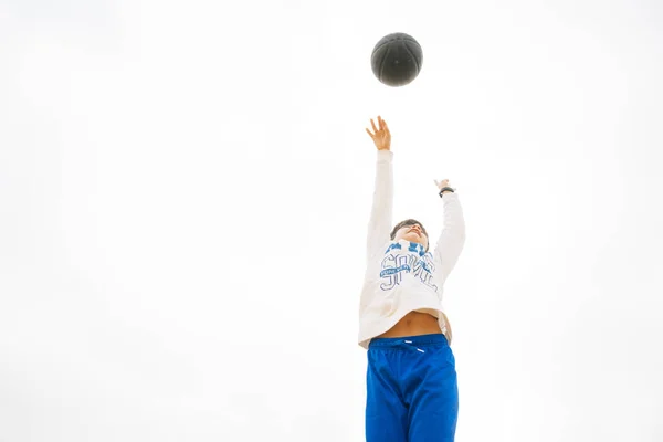 Junge spielt auf gelbem Basketballplatz im Freien. — Stockfoto