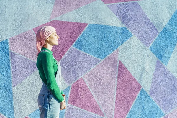 Woman with headscarf fighting cancer on a colorful wall — Stock Photo, Image