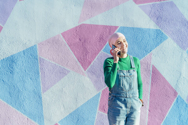 Woman with headscarf fighting cancer is with her smartphone