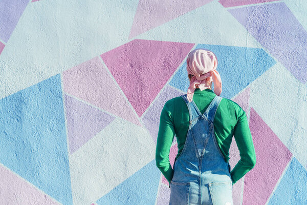 Woman from back to camera with headscarf fighting cancer