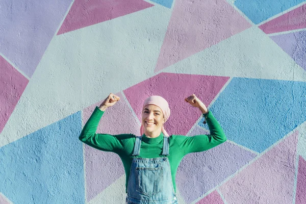 Retrato de mujer con pañuelo rosa, tiene cáncer. Muestra los brazos como un signo de fuerza . — Foto de Stock