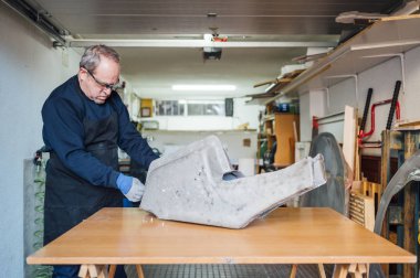 62 yaşında fiber atölyesinde çalışan bir adam.