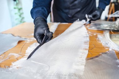 62 yaşında bir adam atölyede fiber kesiyor..