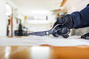 62 yaşında bir adam atölyede fiber kesiyor..