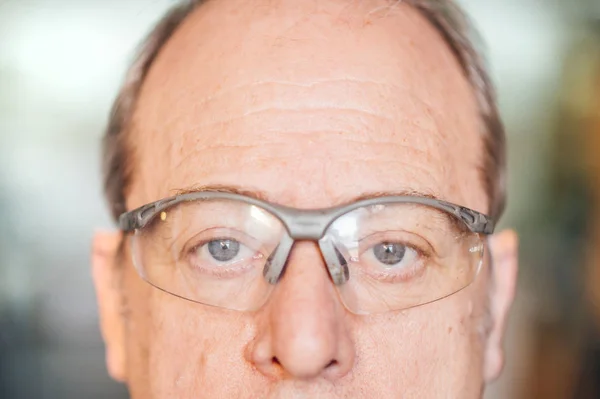 Hombre de 62 años con gafas de seguridad en el taller de fibra . — Foto de Stock