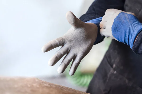 Hombre de 62 años trabajando en la tienda de fibra, se pone guantes —  Fotos de Stock