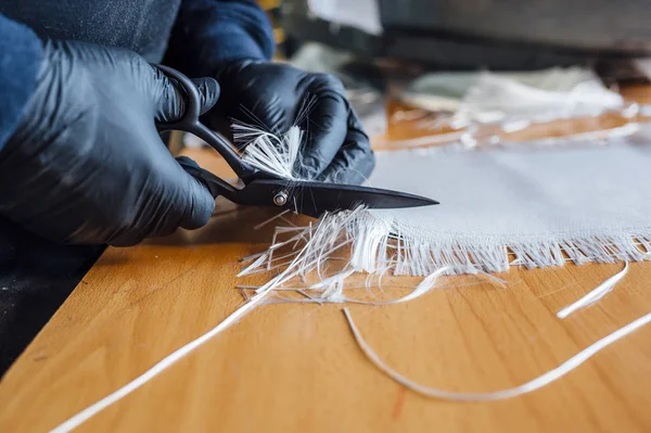 62 jaar oude man snijden vezel met een schaar in de werkplaats. — Stockfoto