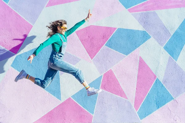カラフルな背景の前でジャンプする女性 — ストック写真