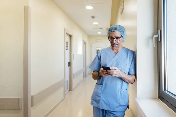 Chirurg mit Smartphone im Operationssaal — Stockfoto