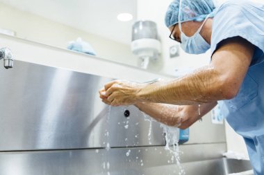 Ameliyattan önce ellerini yıkayan bir doktor. Hastane Konsepti.