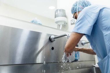 Ameliyattan önce ellerini yıkayan bir doktor. Hastane Konsepti.