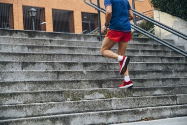 Tanımlanamayan kıdemli adam merdivenlerden yukarı koşuyor.