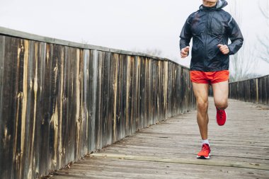 Emekli kıdemli adam koşuyor ve egzersiz yapıyor.