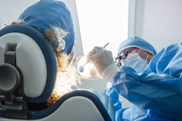 Tandläkare under en dental intervention med en patient. Tandkliniken koncept. — Stockfoto