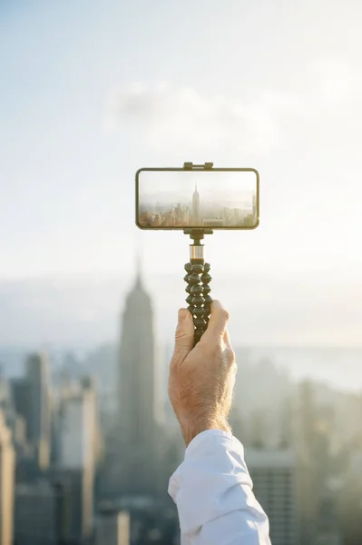 Turistas tirando fotos com o smartphone da paisagem urbana de Nova York de um prédio — Fotografia de Stock