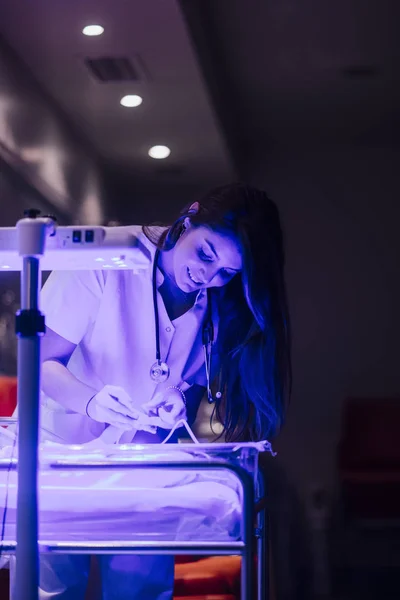 Parent gently touching fragile newborn in neonatal incubator — ストック写真