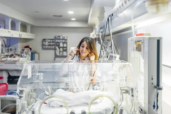 Nursa que afecta suavemente a los frágiles recién nacidos en la incubadora neonatal. — Foto de Stock