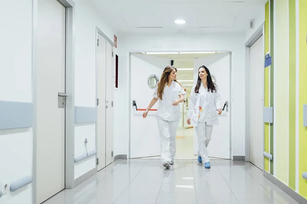 Enfermera y enfermera que camina por el pasillo del hospital - —  Fotos de Stock