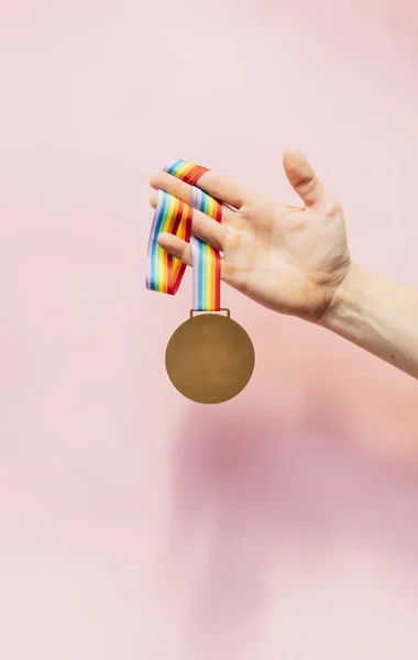 Medalha com fita colorida pendurada na mão — Fotografia de Stock