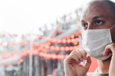 Adam Çin tapınağının yanında maske takıyor. Virüs konsepti