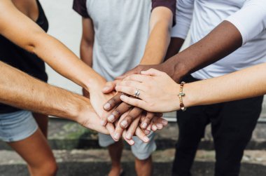 Farklı insanlar el ele tutuşuyor.