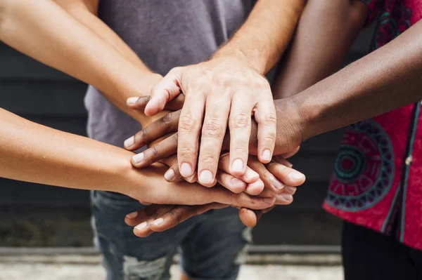 Different unrecognizable people putting their hands on the stack