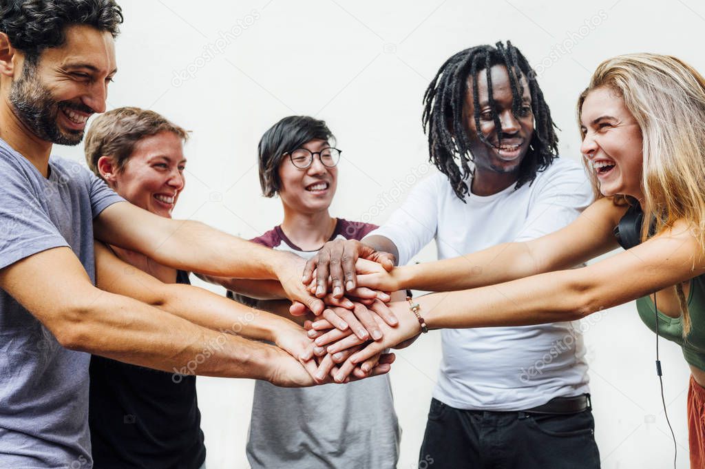 Different people putting their hands on the stack smiling