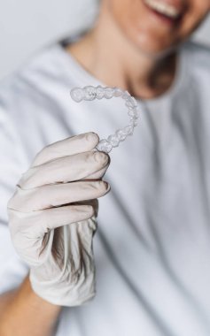 Diş laboratuarındaki insanlar diş saydam hizalayıcıların imalat sürecinde çalışıyorlar.