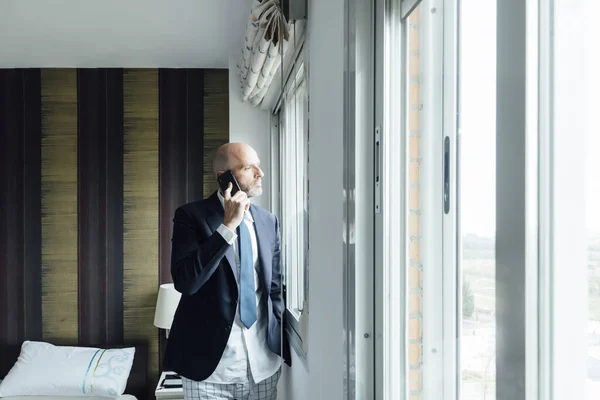 Businessman by the window with smart phone