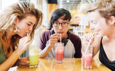 Bir grup arkadaş barda meyve suyu içiyor.