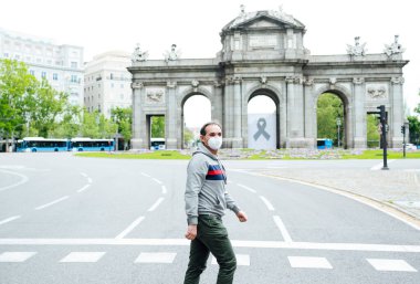 Madrid şehrinde maskeli bir adam yürüyor.