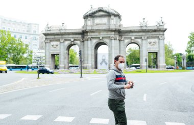 Madrid şehrinde maskeli bir adam yürüyor.