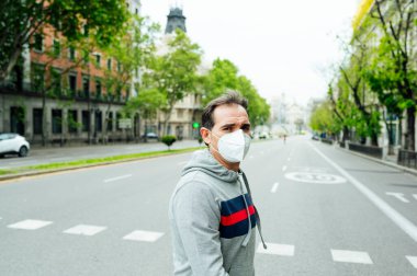 Madrid şehrinde maskeli bir adam yürüyor.