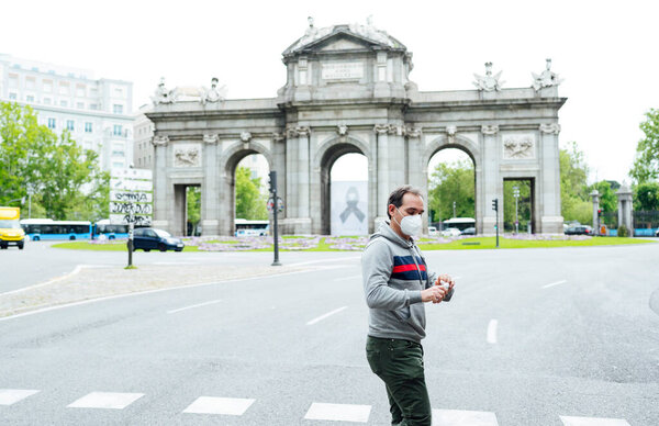 Man walking through the city of Madrid with mask