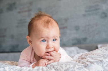 5 aylık bebek bir yatakta yatarken. 