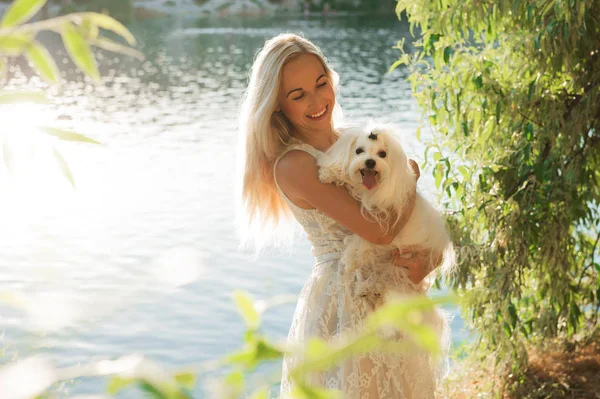 Mujer rubia abrazando perro maltés — Foto de Stock