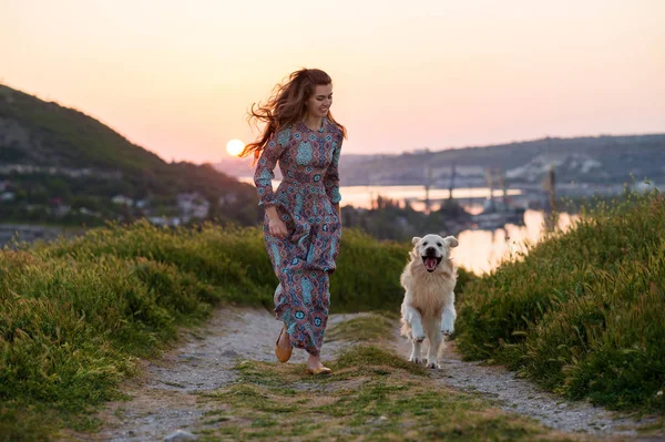 Mujer con su perro jugando al aire libre . — Foto de Stock