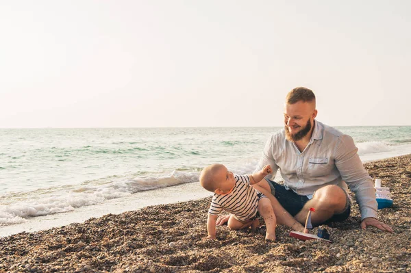Isä ja poika lepäävät rannalla. — kuvapankkivalokuva