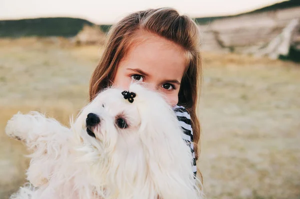 Fille étreignant chien maltais — Photo