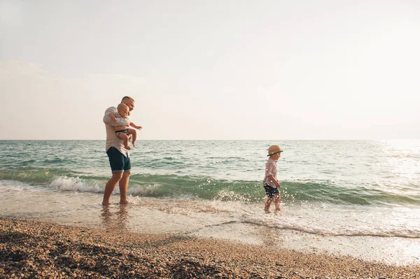 Papá y los niños caminando en la costa del mar . —  Fotos de Stock