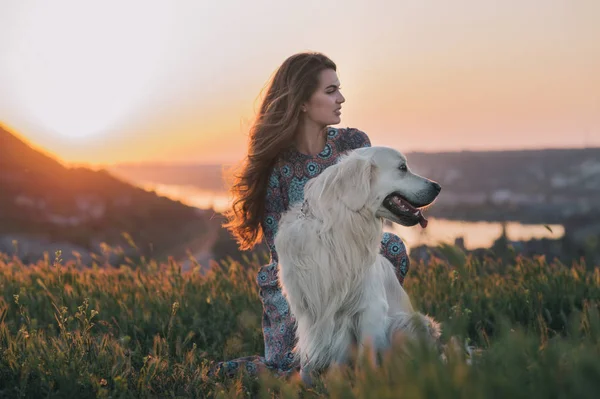 Femme avec son chien profitant du coucher du soleil . — Photo