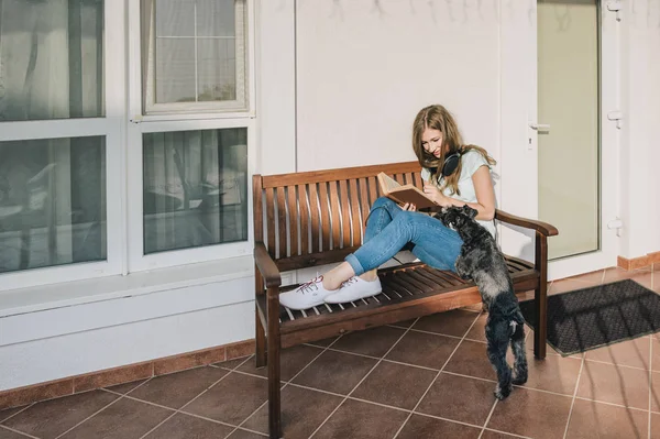 Adolescente Sonriente Sentada Porche Casa Leyendo Libro Mujer Con Mascota Imagen de stock