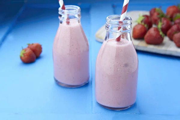 Strawberry milkshake in bottles with straws — Stock Photo, Image