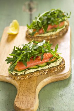 Ahşap tahta üzerinde açık yüz somon sandviç 