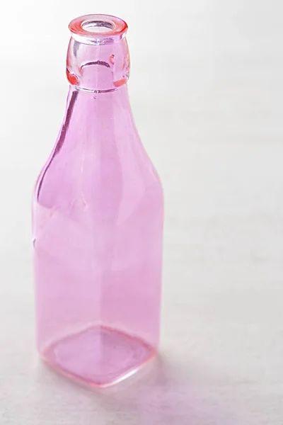 Розовая бутылка на белом фоне — стоковое фото