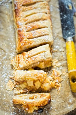 Apple strudel kuru üzüm ve badem ile dilimlenmiş ve ile krema şeker serpilir