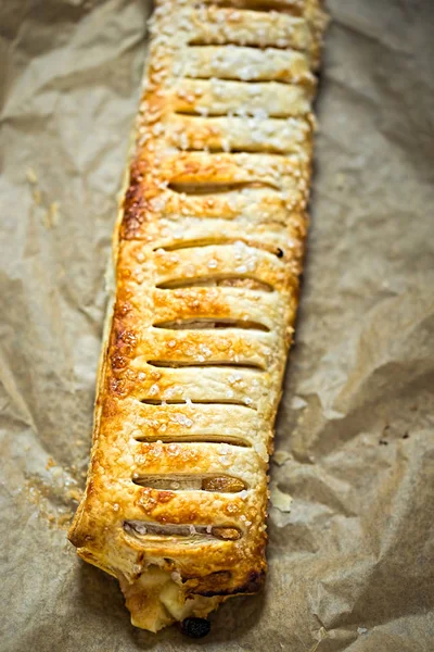 Apple strudel kuru üzüm ve badem ile dilimlenmiş ve ile krema şeker serpilir