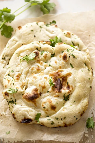 Coriander naan bread on wooden board Stock Picture